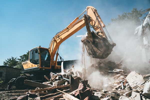 Excavator performing commercial job site demolition