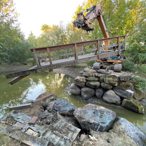 Excavator lifting bridge used for private driveway going over water