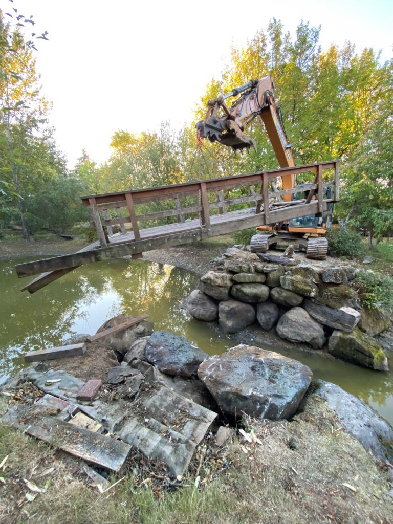 Excavator lifting bridge used for private driveway going over water