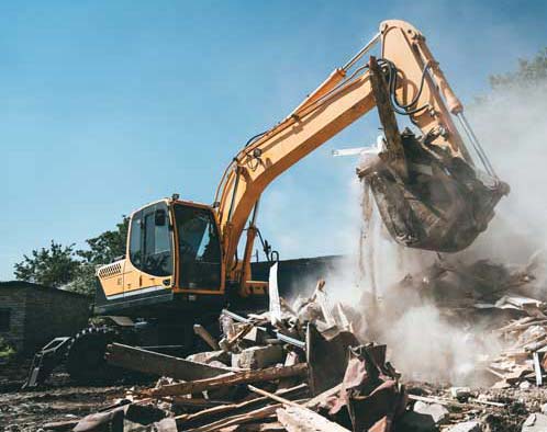 Excavator performing commercial job site demolition