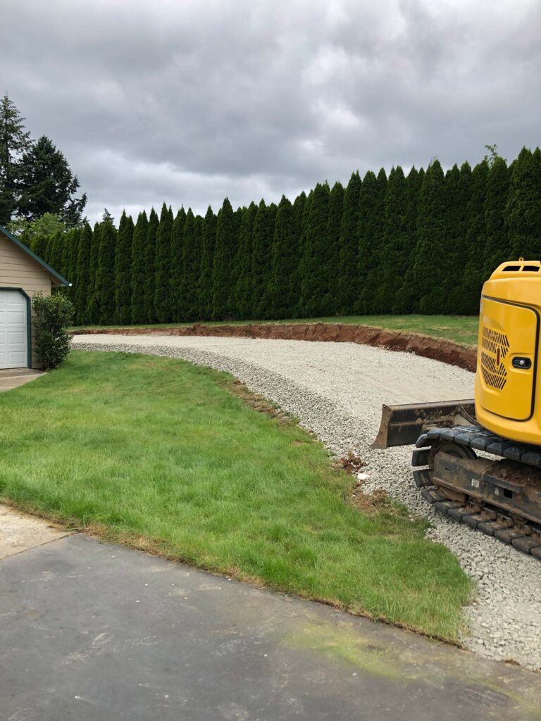 ZPacking down new gravel with heavy machinery at residential home to prepare for driveway